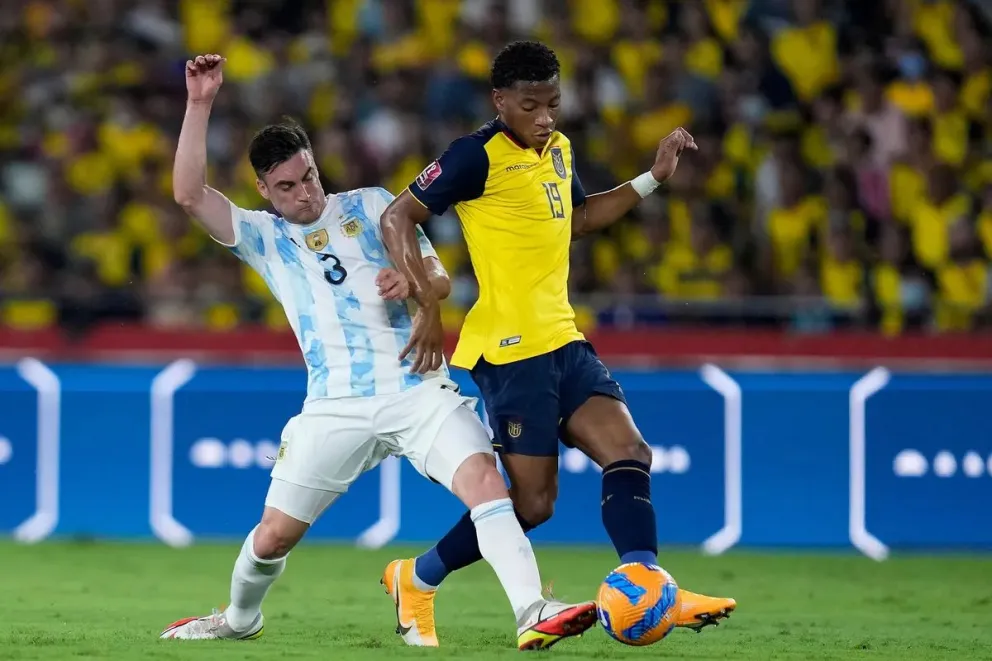 Nicolás Tagliafico lucha por la pelota con el ecuatoriano Gonzalo Plata