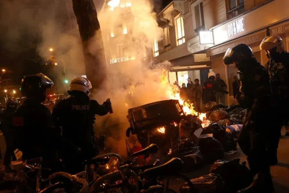 La policía antidisturbios francesa intenta extinguir un incendio