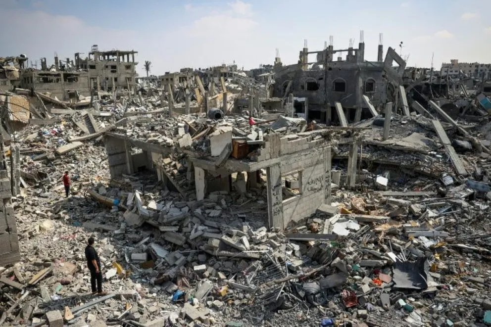 Residentes de Jan Yunis observan los escombros de viviendas destruidas por bombardeos israelíes en esa ciudad del sur de la Franja de Gaza el 16 de abril de 2024
AFP