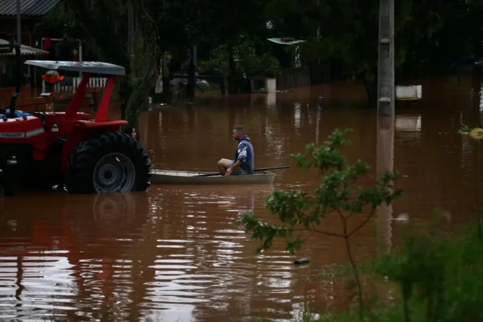 Un hombre se transporta en una zona inundada por las lluvias este viernes, en Porto Alegre (Brasil). EFE/ Renan Mattos